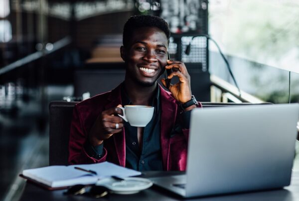 Man drinking coffee while on the phone